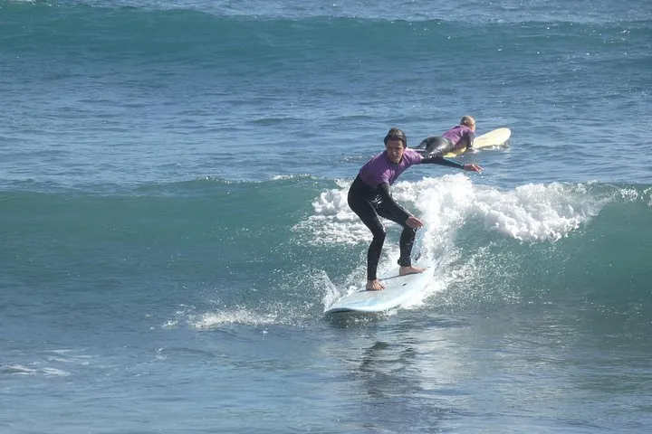 Beginner+ student riding a right hand green wave
